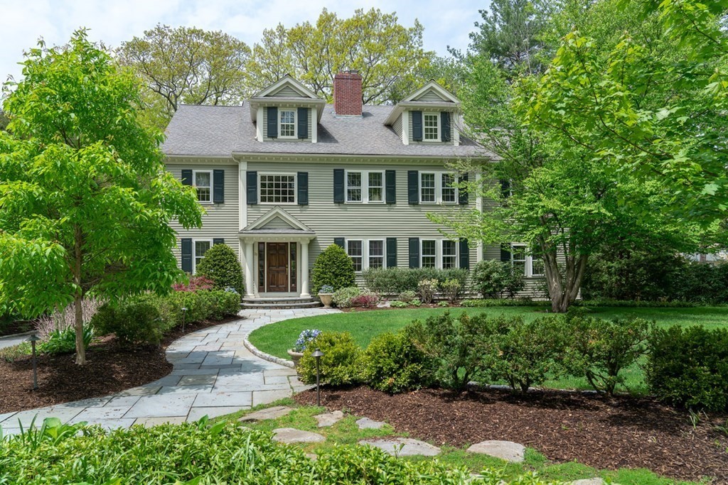 a front view of a house with a yard and trees