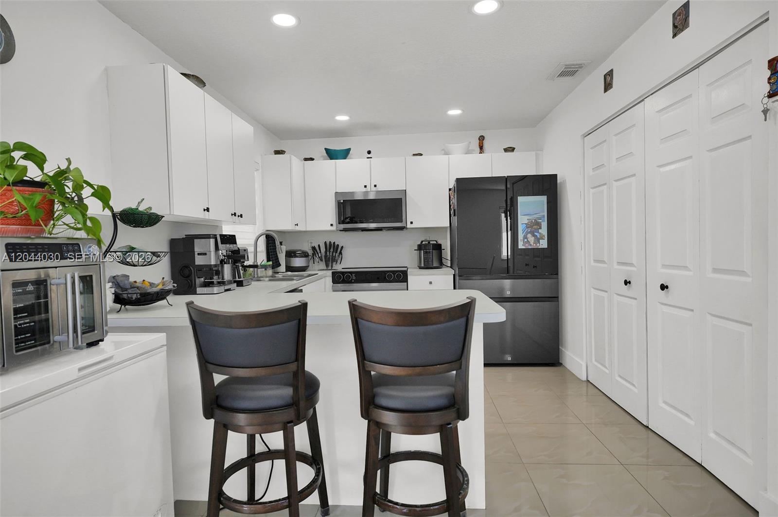 12551 Southwest 223rd Street Miami, FL 33170 - Photo 7 of 35 a kitchen with stainless steel appliances kitchen island granite countertop a refrigerator and a stove top oven