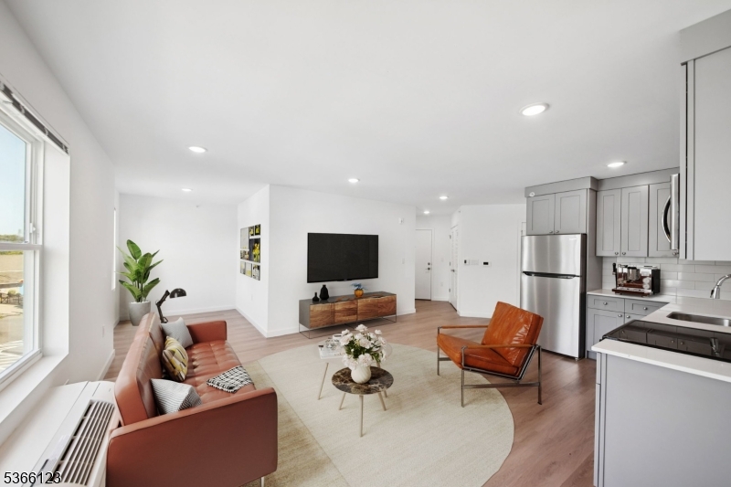a living room with furniture kitchen view and a window
