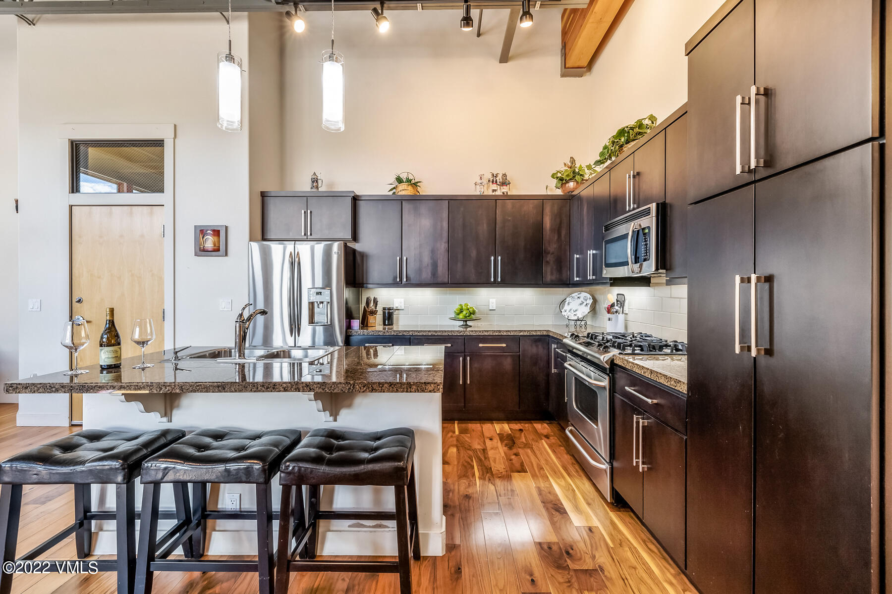 1185 Capitol Street, Unit 203 Eagle, CO 81631 - Photo 12 of 22 a kitchen with stainless steel appliances granite countertop a stove top oven a refrigerator a sink and a stove with wooden floor