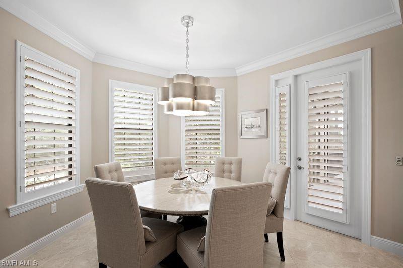 16391 Viansa Way, Unit 101 Naples, FL 34110 - Photo 15 of 49 a view of a dining room with furniture windows and wooden floor