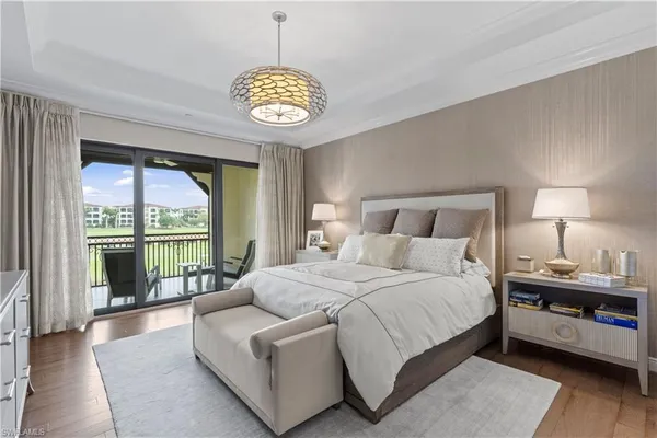 a spacious bedroom with a bed and a chandelier