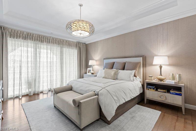 16391 Viansa Way, Unit 101 Naples, FL 34110 - Photo 24 of 49 a spacious bedroom with a bed and a chandelier