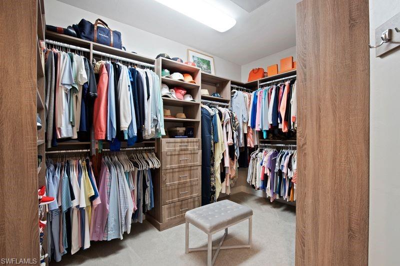 16391 Viansa Way, Unit 101 Naples, FL 34110 - Photo 27 of 49 a view of walk in closet with clothes and shoes