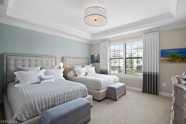 a bedroom with two beds and painting on the wall