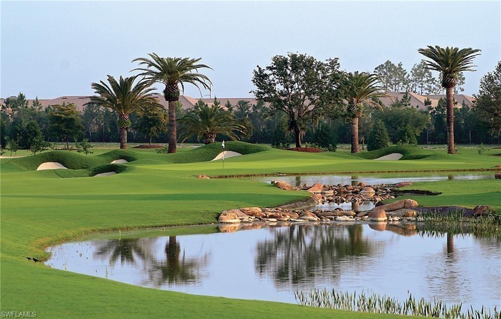 16391 Viansa Way, Unit 101 Naples, FL 34110 - Photo 47 of 49 a view of a lake with a yard and palm trees