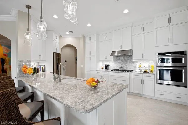 a large kitchen with stainless steel appliances granite countertop a lot of counter space and a sink