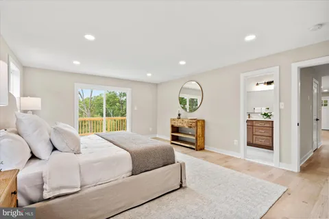 a spacious bedroom with a bed and dresser with mirror