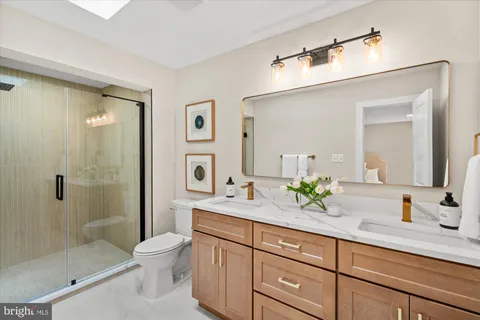 a bathroom with a granite countertop sink a toilet and shower