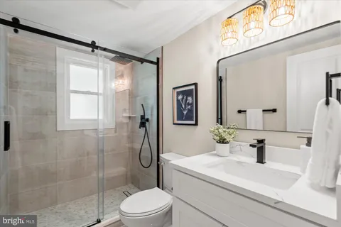 a bathroom with a sink a toilet and shower