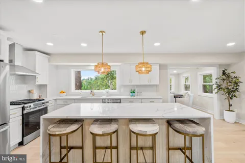 a kitchen with granite countertop a table and chairs in it