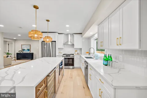 a kitchen with kitchen island stainless steel appliances a sink a counter top space appliances and cabinets