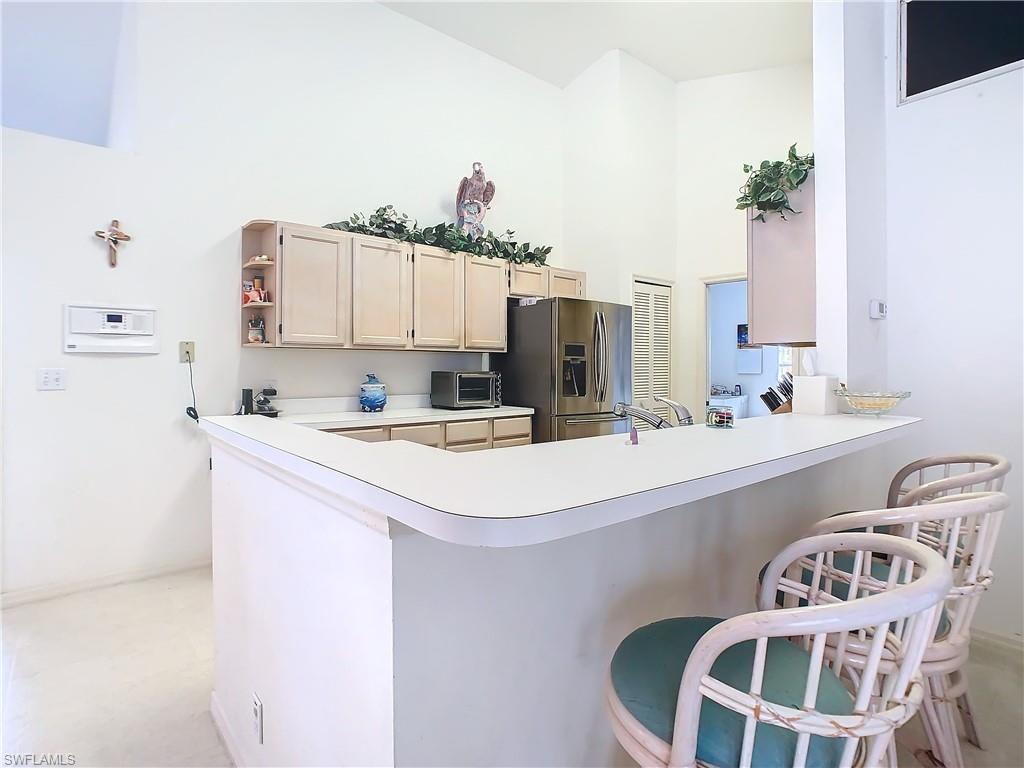 147 Plantation Circle Naples, FL 34104 - Photo 11 of 32 a kitchen with a sink a stove and white cabinets