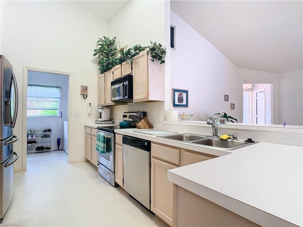 147 Plantation Circle Naples, FL 34104 - Photo 13 of 32 a kitchen with a sink stove and refrigerator