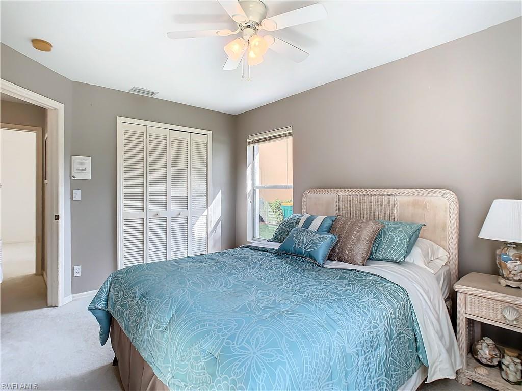 147 Plantation Circle Naples, FL 34104 - Photo 19 of 32 a bedroom with a bed and a chandelier