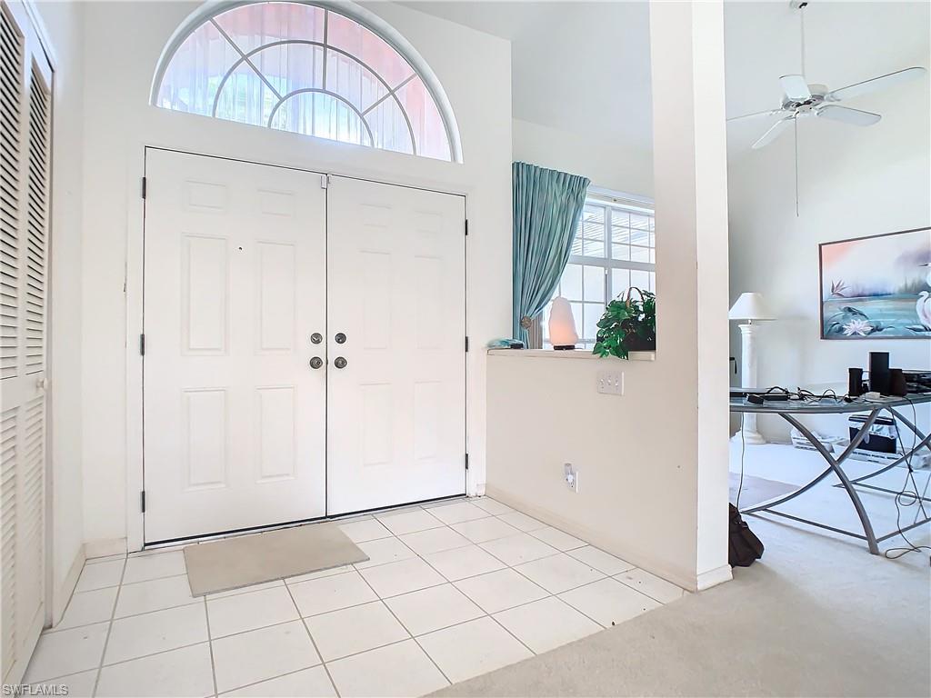 147 Plantation Circle Naples, FL 34104 - Photo 4 of 32 an entryway with a chandelier fan and wooden floor
