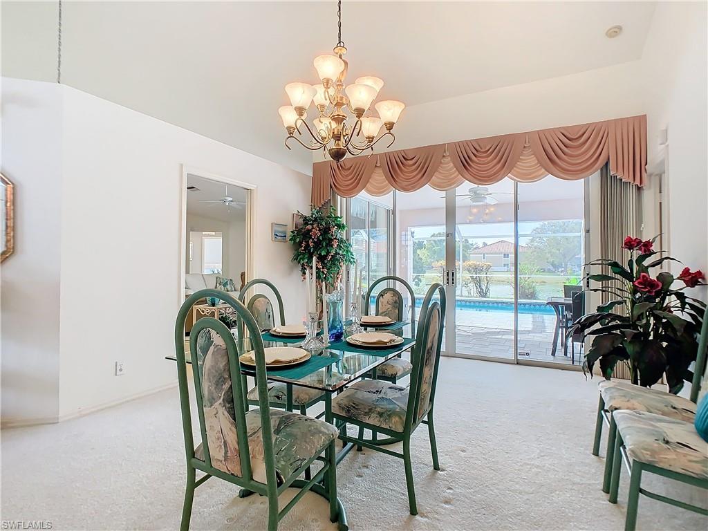 147 Plantation Circle Naples, FL 34104 - Photo 6 of 32 a dining room with furniture potted plants and a chandelier