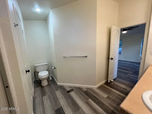 a bathroom with a granite countertop toilet and a shower