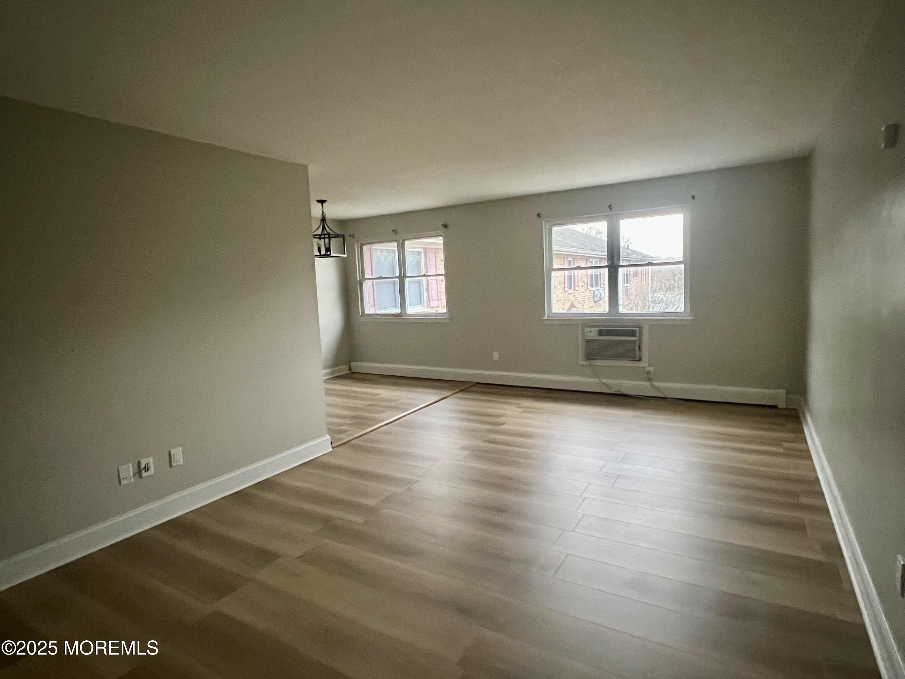 12 Manchester Court, Unit H Freehold, NJ 07728 - Photo 2 of 11 an empty room with wooden floor and windows