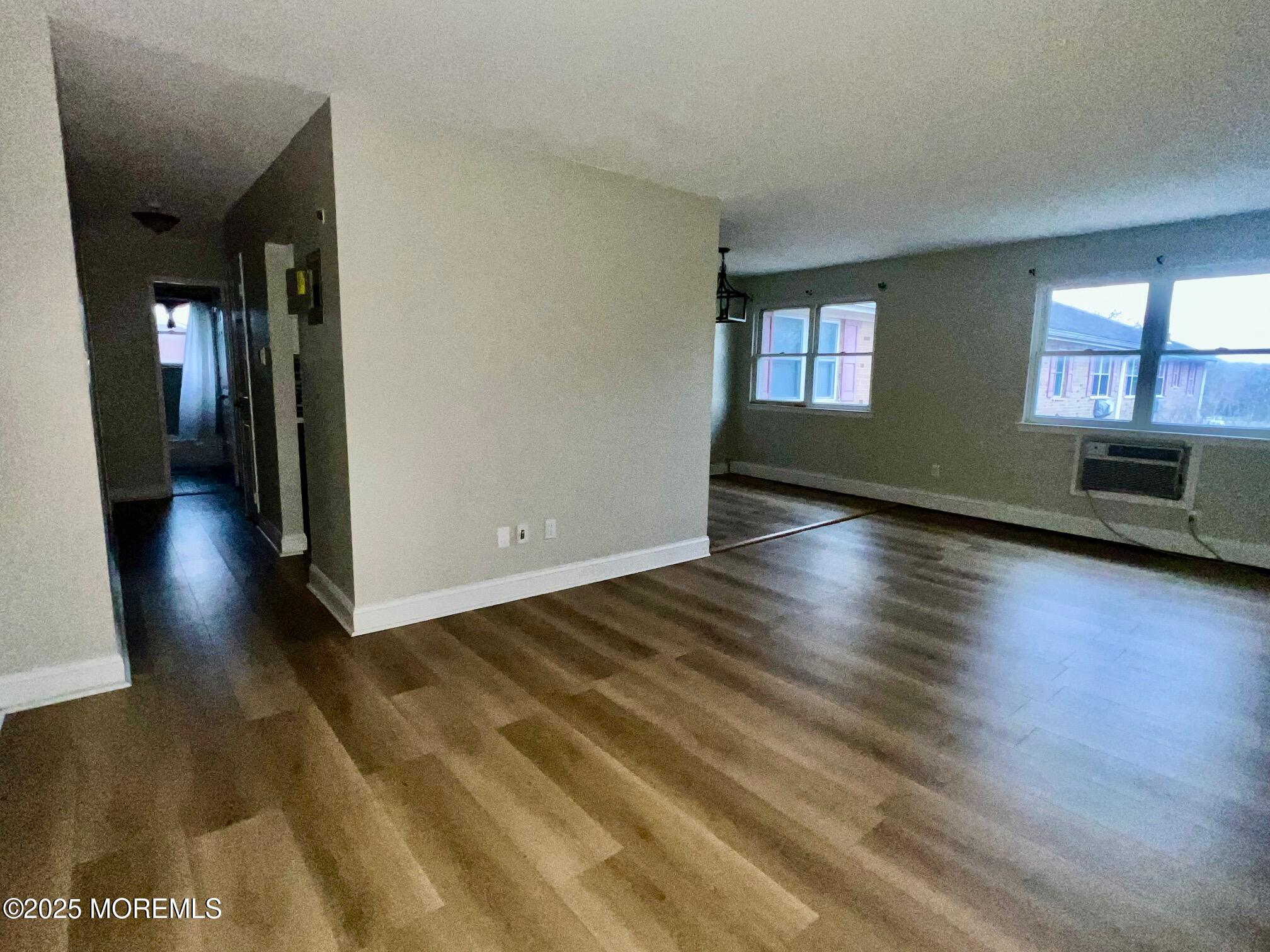 12 Manchester Court, Unit H Freehold, NJ 07728 - Photo 3 of 11 a view of an empty room with window and wooden floor