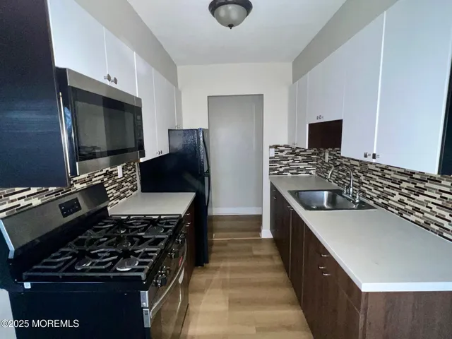 a kitchen with granite countertop a stove and a refrigerator