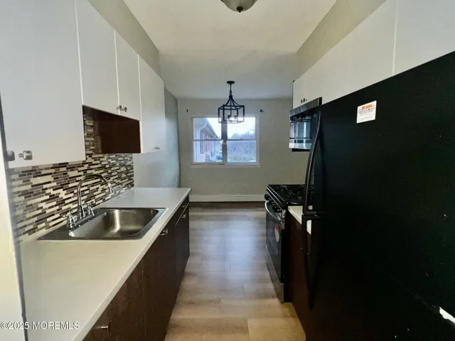 a view of an empty room with wooden floor and closet