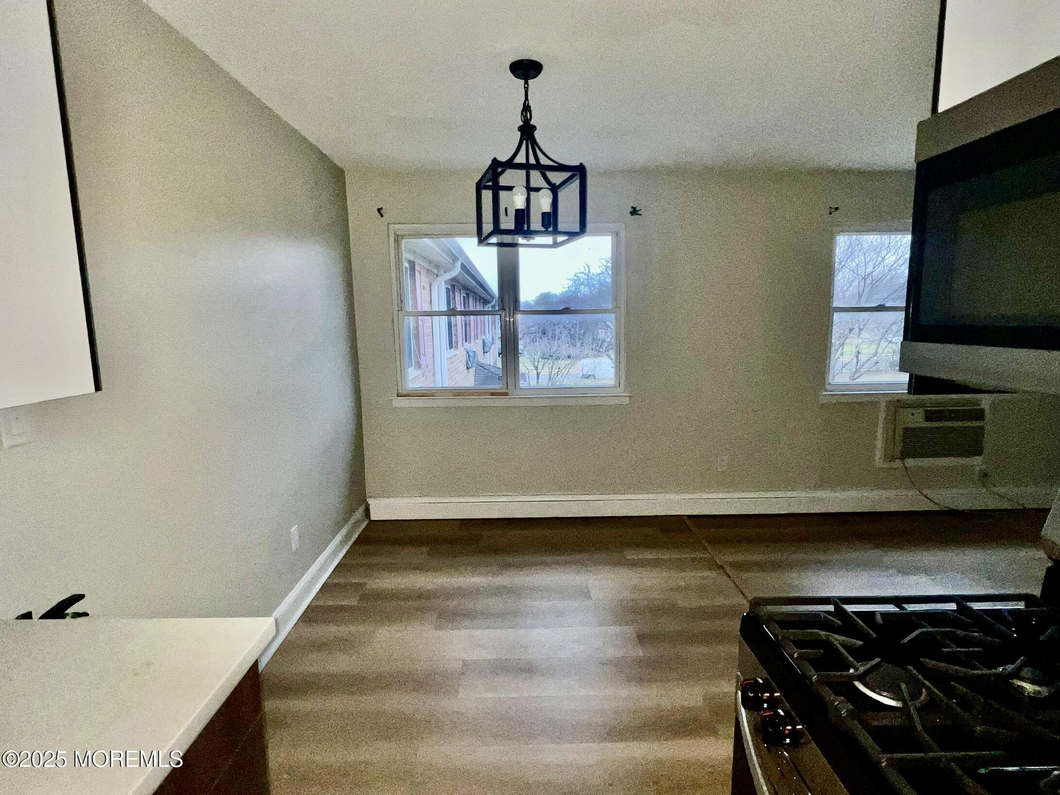12 Manchester Court, Unit H Freehold, NJ 07728 - Photo 7 of 11 a view of a livingroom with wooden floor and a ceiling fan