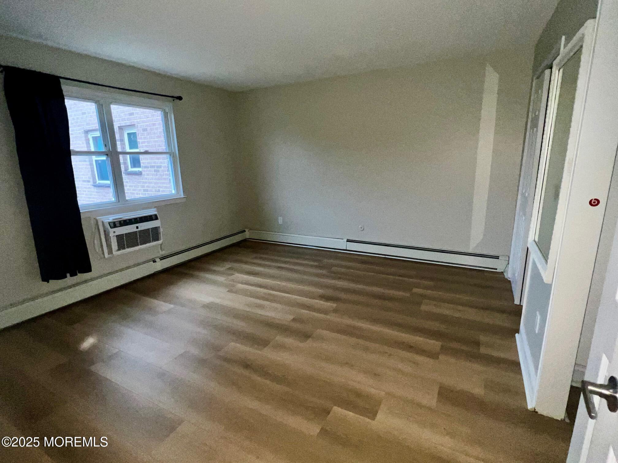 12 Manchester Court, Unit H Freehold, NJ 07728 - Photo 9 of 11 a view of an empty room with a fireplace and a window