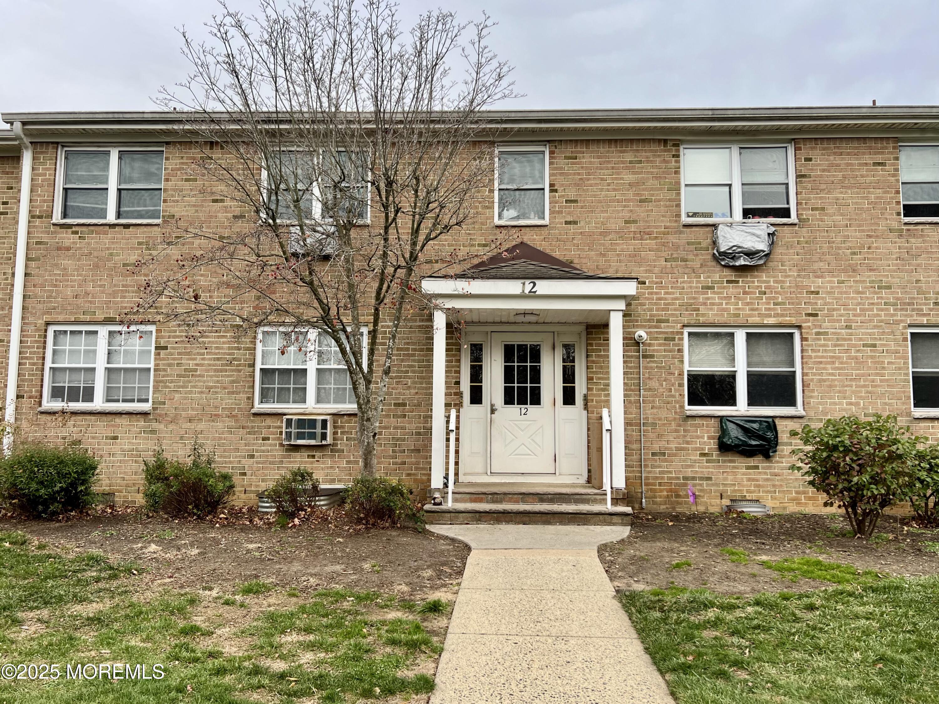 12 Manchester Court, Unit H Freehold, NJ 07728 - Photo 10 of 11 front view of a house with a yard