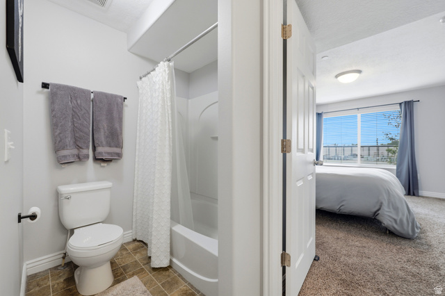 116 East Resaca Drive, Unit F6 Sandy, UT 84070 - Photo 23 of 32 Bathroom featuring a white toilet, a shower-over-tub combination with a white shower curtain, and wood-finish tile flooring