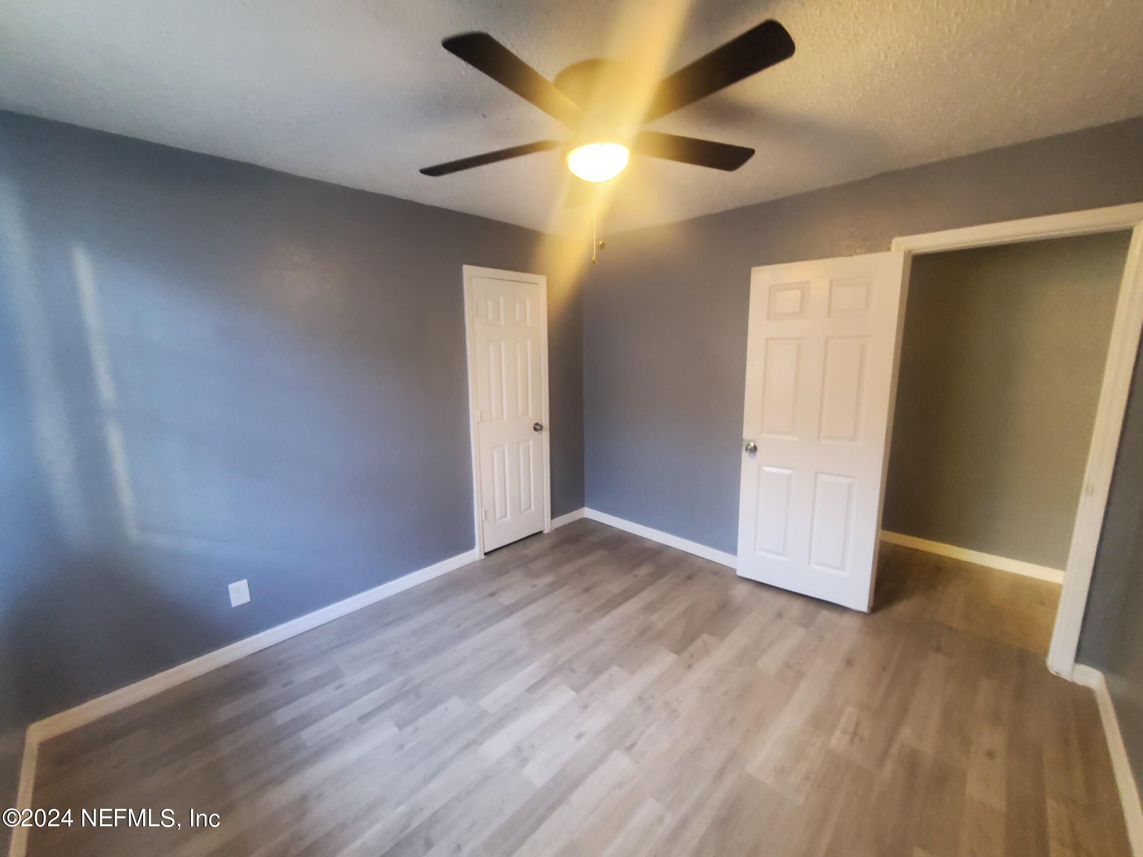 4114 Moncrief Road Jacksonville, FL 32209 - Photo 6 of 15 an empty room with wooden floor and windows