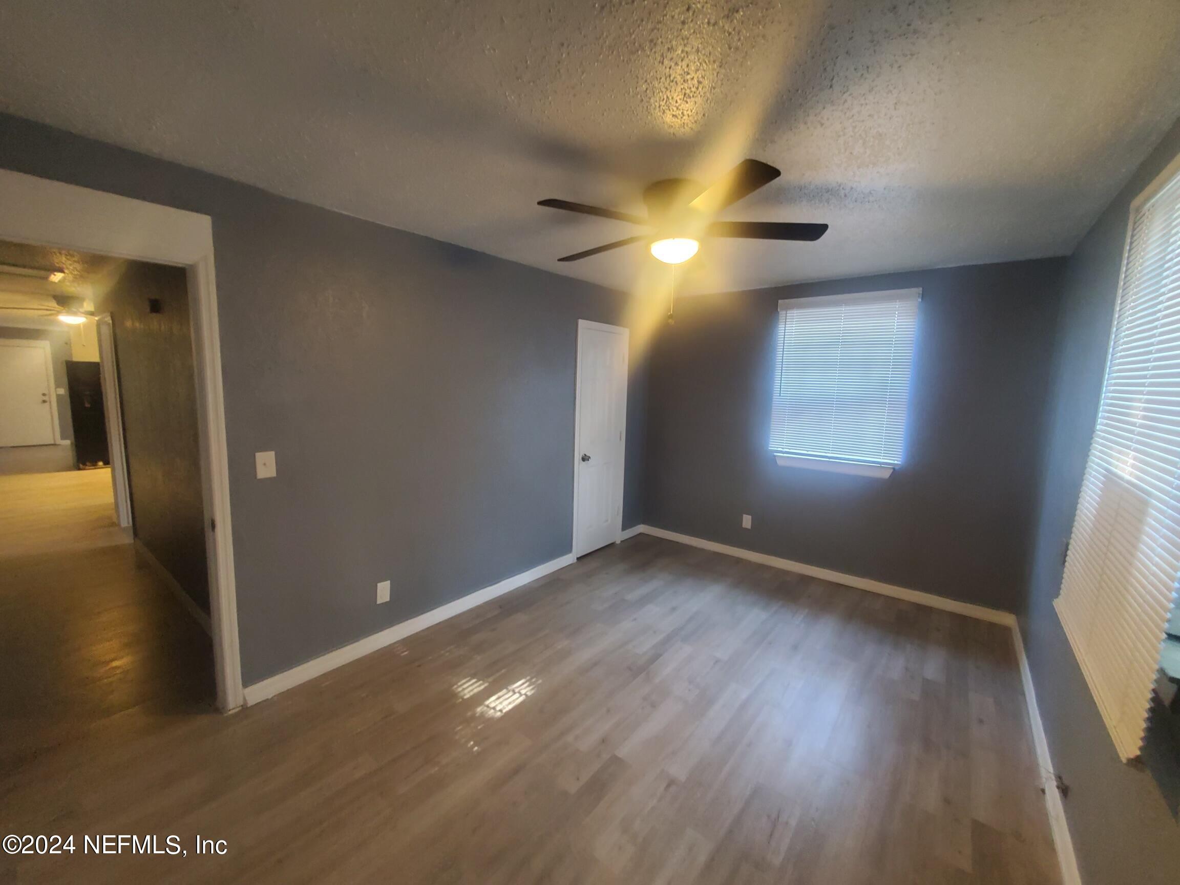 4114 Moncrief Road Jacksonville, FL 32209 - Photo 8 of 15 an empty room with wooden floor and windows
