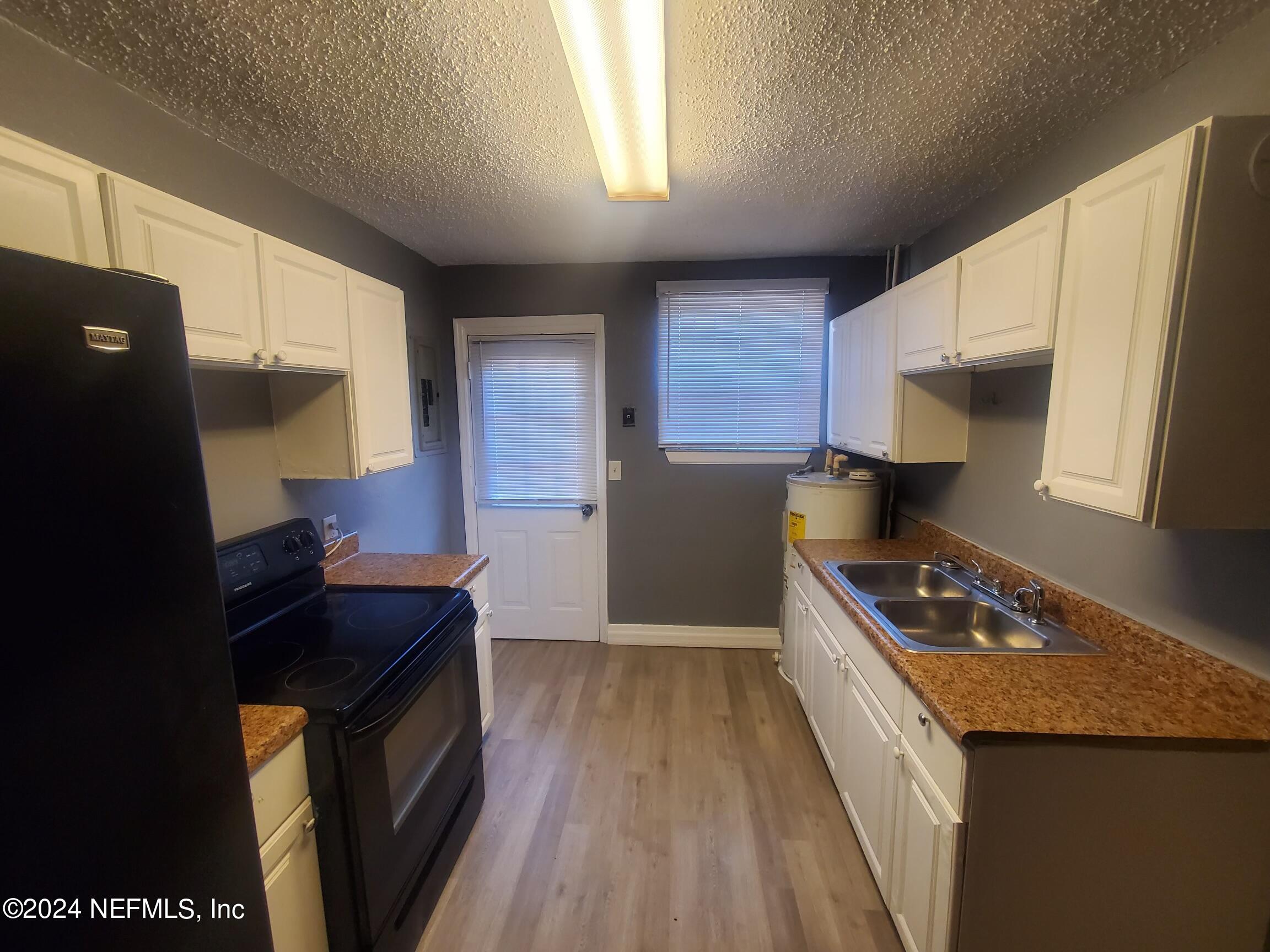 4114 Moncrief Road Jacksonville, FL 32209 - Photo 9 of 15 a kitchen with granite countertop a sink stove and refrigerator