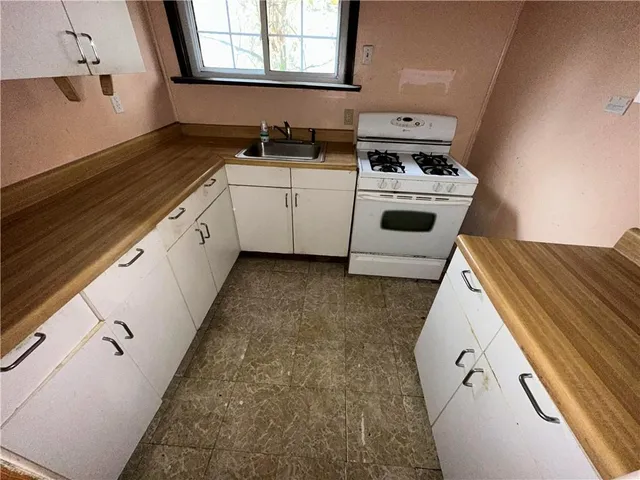 a kitchen with a sink stove and cabinets
