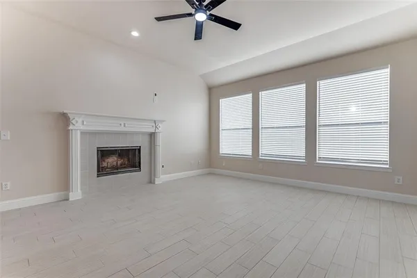 wooden floor fireplace and windows in an empty room