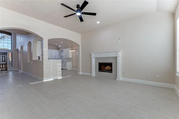 a view of an empty room with a fireplace and a window