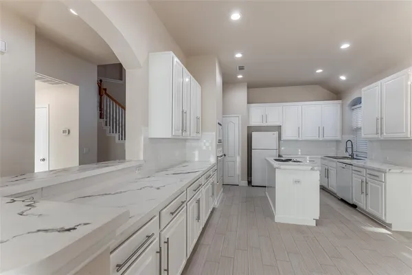 a kitchen with a sink stove cabinets and refrigerator