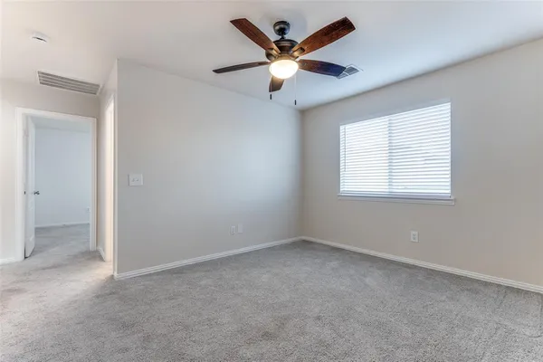 an empty room with a ceiling fan and window