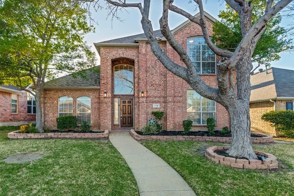 a front view of a house with a yard and fountain