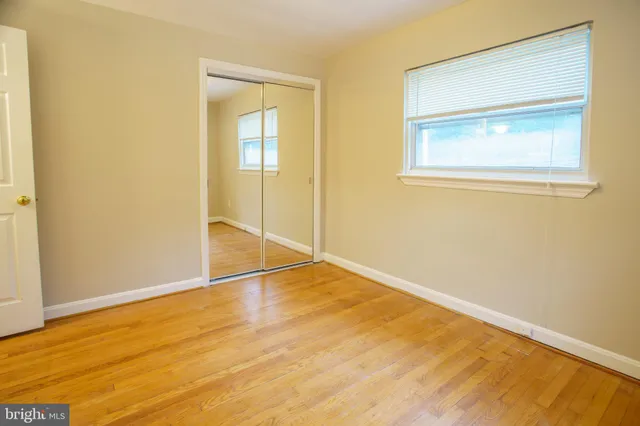 an empty room with wooden floor and a window