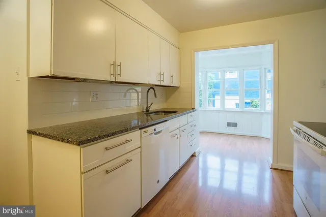 a kitchen with granite countertop a sink and a stove top oven