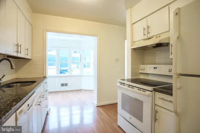 a kitchen that has a stove a sink and a microwave