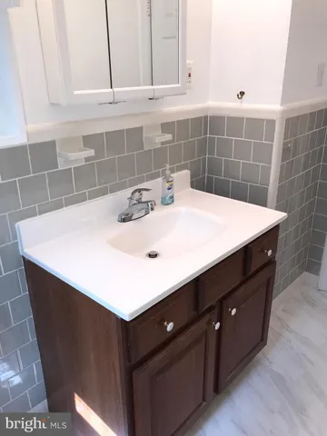 a bathroom with a sink vanity and a mirror