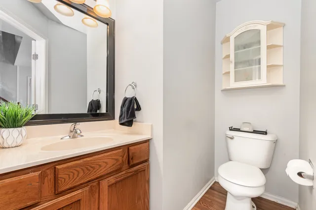 a bathroom with a sink toilet and large mirror