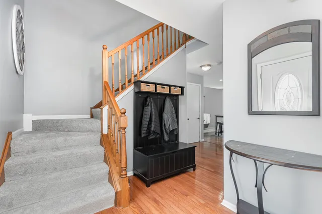 a living room with stairs and a wooden floor