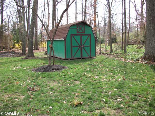 2541 Radstock Road Midlothian, VA 23113 - Photo 7 of 12 a view of a tiny house with a yard and large trees
