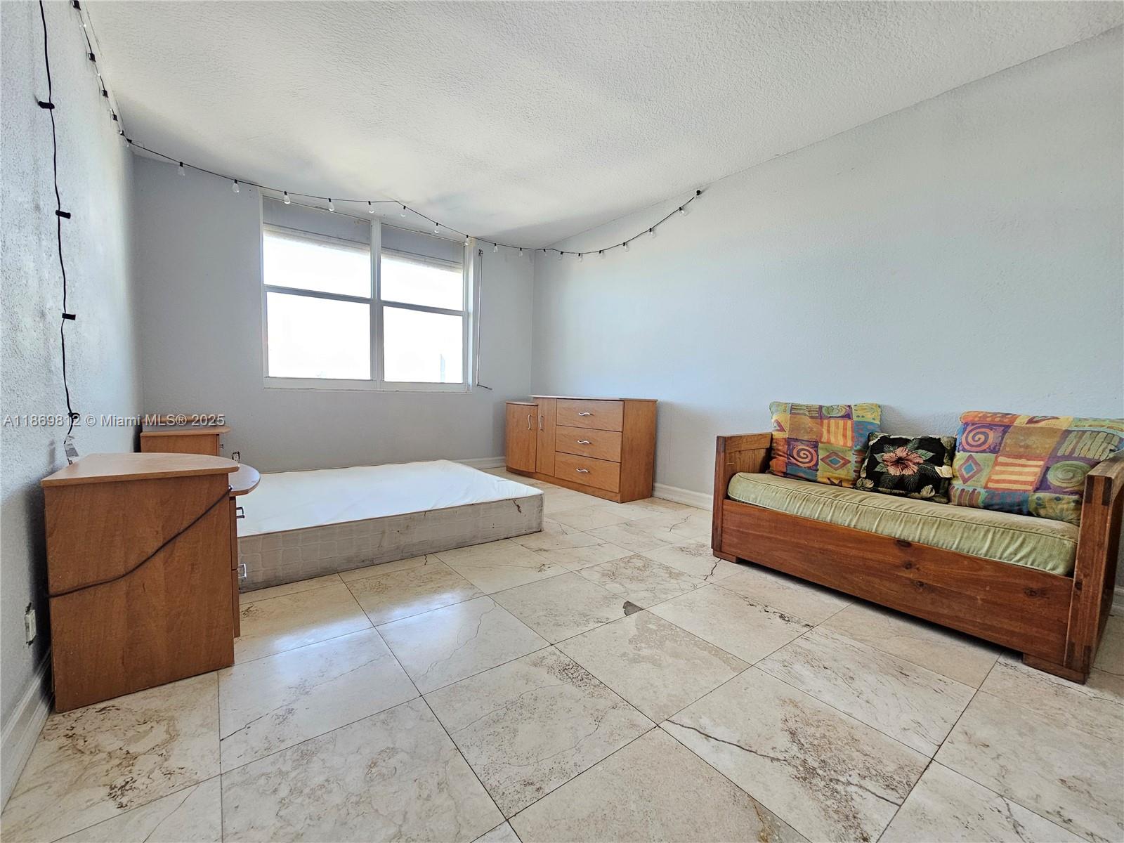 427 Golden Isles Drive, Unit 16E Hallandale Beach, FL 33009 - Photo 11 of 17 a spacious bedroom with a bed and window