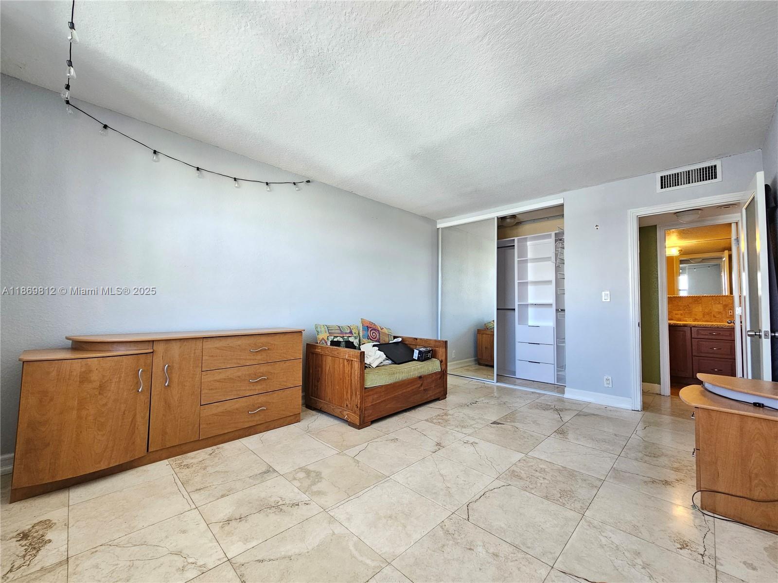 427 Golden Isles Drive, Unit 16E Hallandale Beach, FL 33009 - Photo 12 of 17 a bedroom with furniture and window
