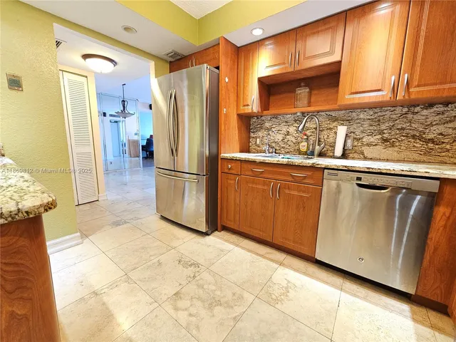 a kitchen with granite countertop a refrigerator and a sink