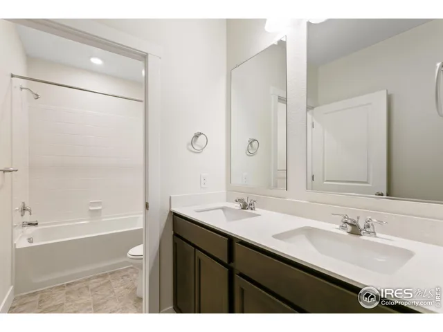 a bathroom with a sink double vanity granite tub shower and a mirror